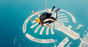 A man riding a parachute in the air in Dubai