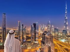 Arabian man watching night cityscape of Dubai.