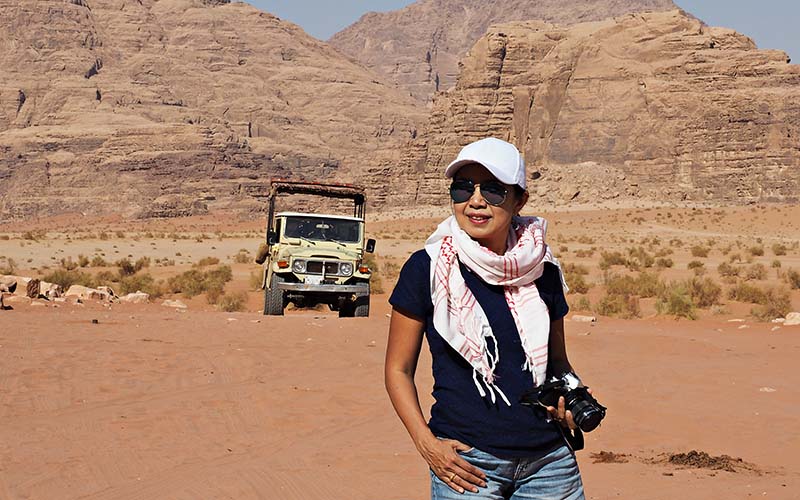 Woman Carrying Camera in Desert