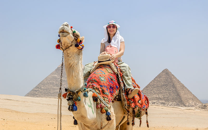 Woman Riding a Camel in the Desert
