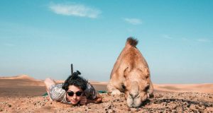 women next to camel at lahbab desert safari
