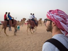 An Arabian man watching camels at desert safari.