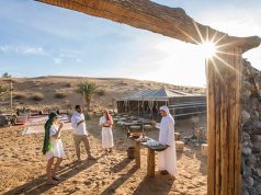 Guests enjoying a traditional welcome at a luxury desert safari camp.