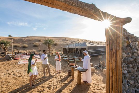 Guests enjoying a traditional welcome at a luxury desert safari camp.