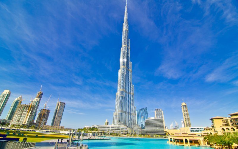 Daytime view of Burj Khalifa with clear blue sky and reflecting water nearby Daytime view of Burj Khalifa with clear blue sky and reflecting water nearby