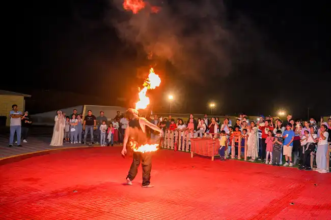 Fire performer entertaining guests during a desert safari night show in Dubai