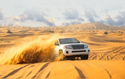 Dune bashing adventure during a morning desert safari in Dubai, with 4x4 vehicles racing across golden sand dunes.